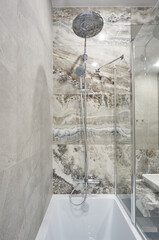 modern minimalist stone bathroom with shower and washing machine