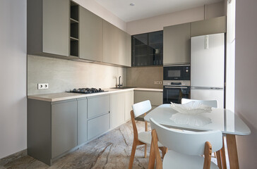 modern scandinavian minimalist kitchen in monochrome color with a showcase and a built-in oven and...