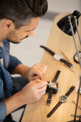 clockmaker repairing wrist watch with macro shot