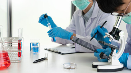 Team of Medical Research Scientists or researcher in lab coat testing their experimental in Modern...