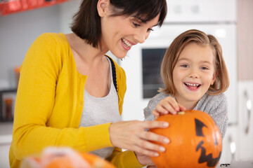 mother and daughter preparing halloween pumpkin