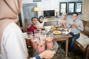 a group of coworkers having lunch together were very enthusiastic when their friend served ice in a glass in the dining room in a traditional house