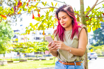 young girl in the park chatting from her smart phone