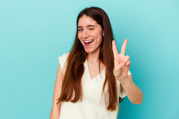 Young caucasian woman isolated on blue background showing number two with fingers.