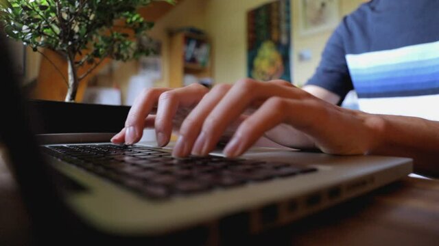 Vue rapproch&eacute;e d&rsquo;un &eacute;tudiant travaillant sur son ordinateur portable. Male student hands typing on laptop at desk, close up view.