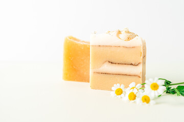 Homemade herbal Soap with chamomile Flowers on white marble background. Zero waste, natural organic bathroom cosmetics. Plastic free life. Ecological skin care, body treatment concept