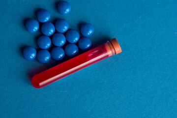 A test tube filled with a blood sample for testing and pills tablets. Coronavirus pandemic epidemic concept.
