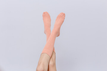 female legs wearing pink socks and has a white background