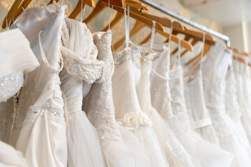 white wedding dress hanging on hangers