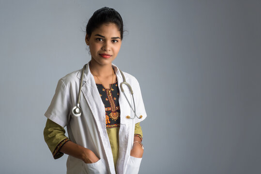 Woman doctor with a stethoscope on grey background