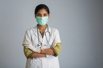 Portrait of woman doctor wearing a protective mask and gloves with a stethoscope. World epidemic of...