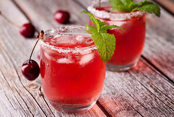 View of two glasses of cherry cocktail on wood table