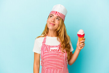 Caucasian ice cream maker woman holding an ice cream isolated on blue background dreaming of achieving goals and purposes