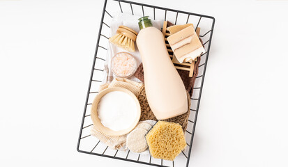 Eco friendly natural cleaners. Basket with baking soda, dish brush, soap, sponge on white...