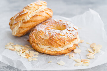 French traditional cake Paris Brest with praline cream, powdered sugar and almond petals on top on...
