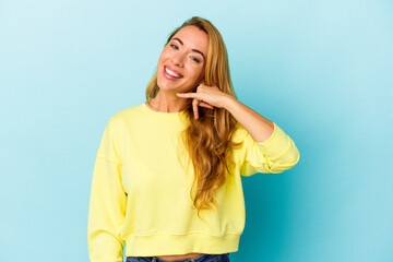 Fototapeta premium Caucasian woman isolated on blue background showing a mobile phone call gesture with fingers.