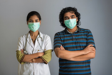 Portrait of young man and woman doctor wearing a protective mask with a stethoscope. World epidemic...