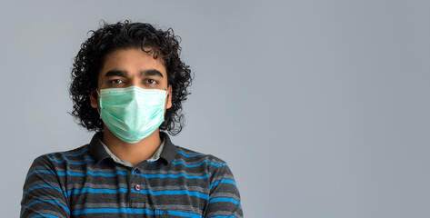 Closeup portrait of a young man wearing a medical or surgical mask