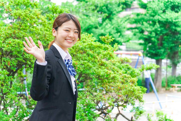 笑顔で手を振る制服姿の学生