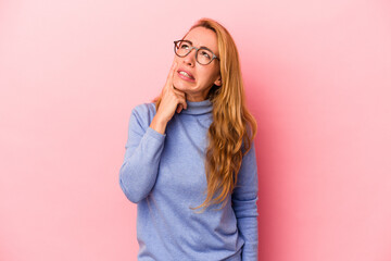 Caucasian blonde woman isolated on pink background crying, unhappy with something, agony and confusion concept.