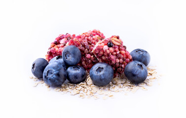 Granola bars with fresh blueberries isolated on white background, close-up. Superfood meal with a blueberry and oat cereal for a healthy snack, vegan menu or dietary food.