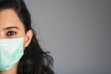 Closeup portrait of a young girl or woman doctor wearing a medical or surgical mask
