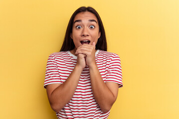 Young mixed race woman isolated on yellow background praying for luck, amazed and opening mouth looking to front.