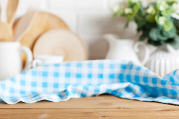 Fototapeta na wymiar Napkin checkered tablecloth on brown wooden kitchen table. Blur rye bokeh background. Selective focus. Place for food and drink.