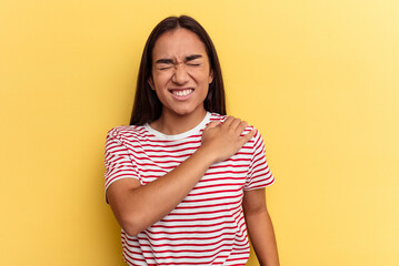Obraz premium Young mixed race woman isolated on yellow background having a shoulder pain.