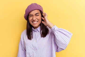 Young mixed race woman isolated on yellow background covering ears with hands.