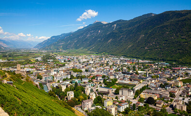 Fototapeta na wymiar Aerial view of Martigny modern cityscape in Rhone Valley at foot of Swiss Alps in sunny summer day, canton of Valais