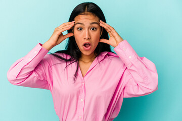 Young Venezuelan woman isolated on blue background receiving a pleasant surprise, excited and raising hands.