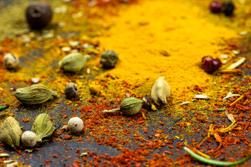 Scattered spices on a black background close-up.