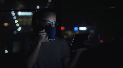 Woman in glasses talking by the tablet pc video conference beside the window. Bokeh on background