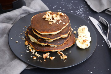 Banana pancakes and walnut crumbs on a black background.