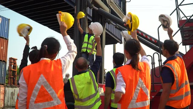 group of factory workers excited and celebrating holding headhat rising up in meeting at industrial factory protect for pollution.