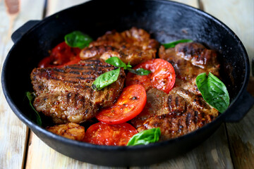 Appetizing juicy grilled steak with grilled vegetables in a pan. Close-up.