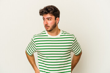 Fototapeta premium Young caucasian man isolated on white background confused, feels doubtful and unsure.