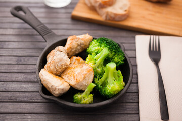 pieces of fried chicken breast with boiled broccoli egg in cast iron portioned skillet