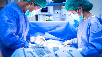 The surgeon and assistant are operating in the operating room.