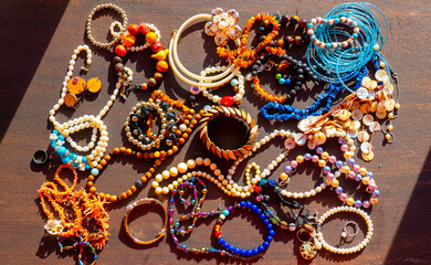 a lot of costume jewelry with different materials on a black background