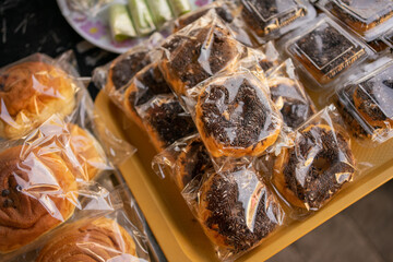 various kinds of traditional Indonesian street food, donuts with mesis wrapped in plastic on a serving plate on the table