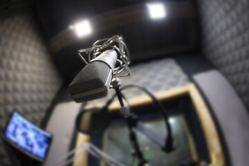 Close-Up Of Microphone and pop filter on acoustic foam panel background in radio station broadcasting studio with copy space. selective focus only fourground