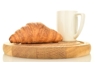 One freshly baked fragrant croissant on a wooden tray with a white cup, close-up, isolated on white.
