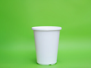 white plastic flower pot over green background.