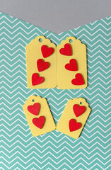 four wooden pastel-yellow chalkboard tags on a zig zag green and white paper background featuring...
