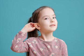 Cute little girl showing new earrings on ear