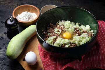 Ingredients for vegetarian pancakes: raw chopped mushrooms, zucchini, garlic, salt, pepper and green buckwheat flour
