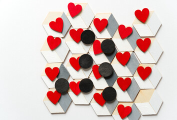 small red hearts and black discs on trompe l'oeil cubes on white