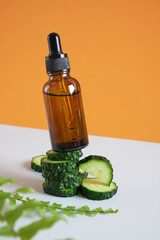 fern leaves, cucumber slices and brown glass dropper bottle, serum or cosmetic oil in a bottle with a dropper